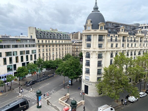 A historic building with a prominent dome and classical architecture, surrounded by modern buildings and a busy street scene. - Appartement Opera Chauchat Citycosy (Paris)