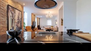 Un soggiorno moderno con un grande tavolo nero, un lampadario e un camino.