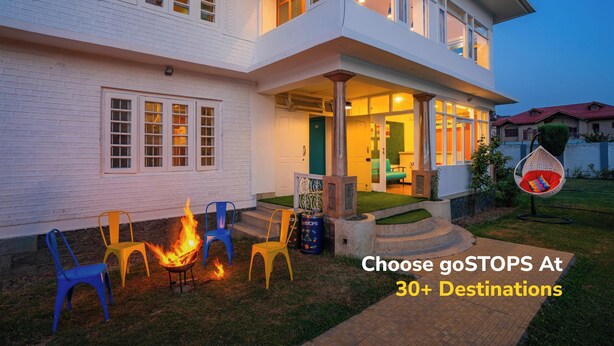 A two-story house with a porch, outdoor seating, and a fire pit. - goSTOPS Srinagar (Srinagar)