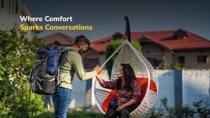 Two people conversing in an outdoor setting with a hanging chair and a house in the background. - goSTOPS Srinagar (Srinagar)