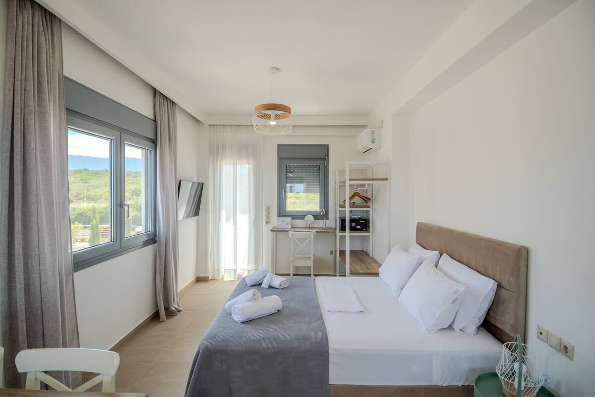 A modern hotel room with a bed, a desk, and a chair.
