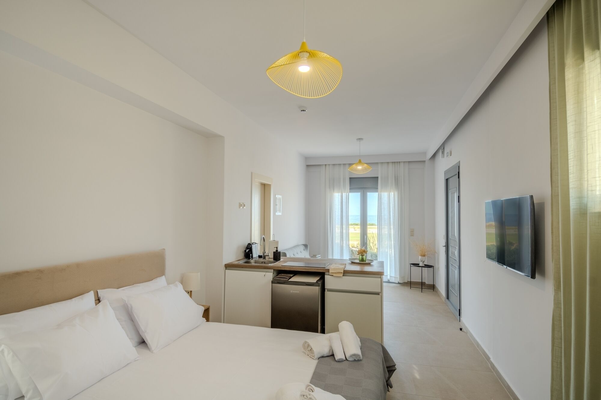 Een hotelkamer met een bed, een bureau, een stoel, een wastafel en een televisie.
