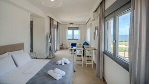 Une chambre d’hôtel avec un lit, un bureau et une vue sur la mer.