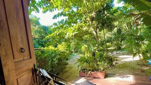 A wooden door with a hanging bag and a chair on a wooden deck. - Comfortable Malagasy bungalow on private beach (Analanjirofo)
