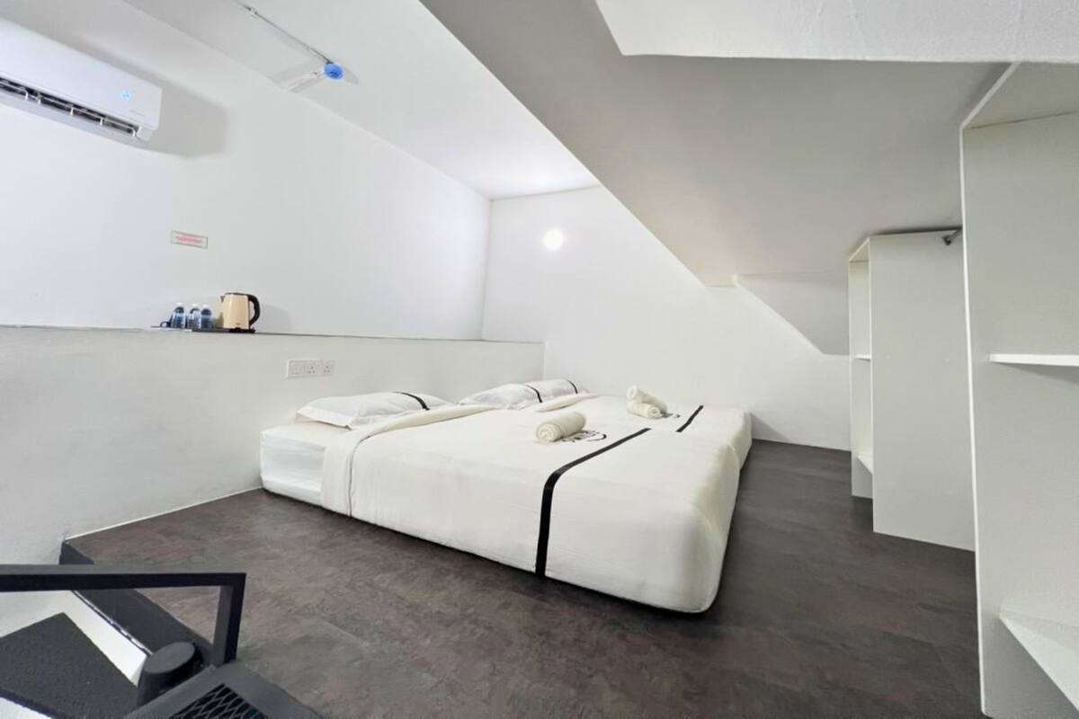 Une chambre d’hôtel moderne équipée d’un lit, d’un bureau et d’un coin cuisine.