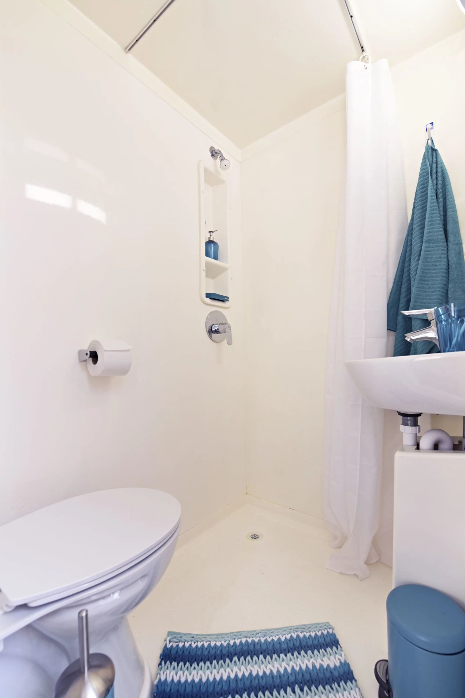 Un bagno con un water, doccia e lavandino.