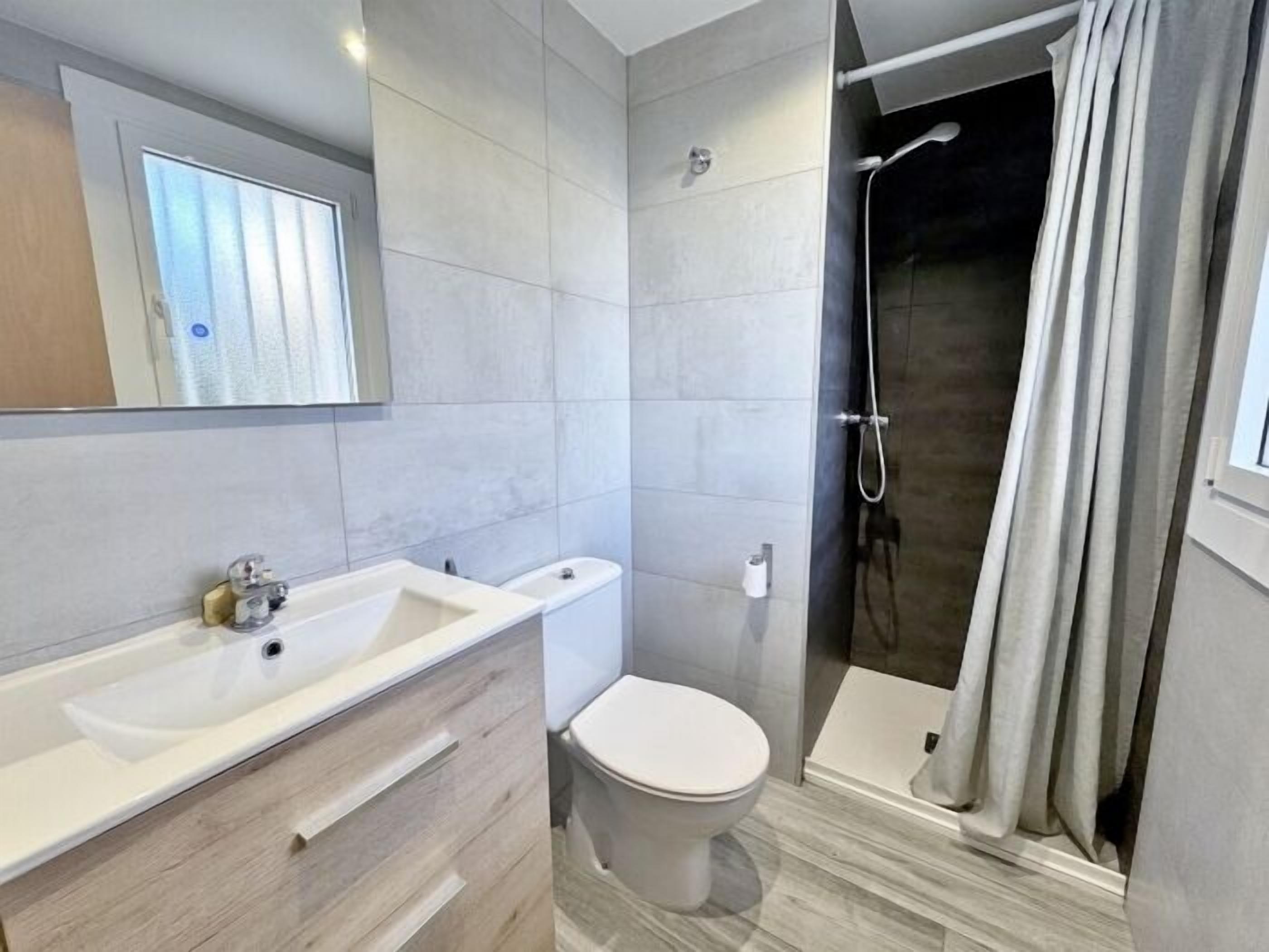 A modern bathroom with a large sink, toilet, and shower.