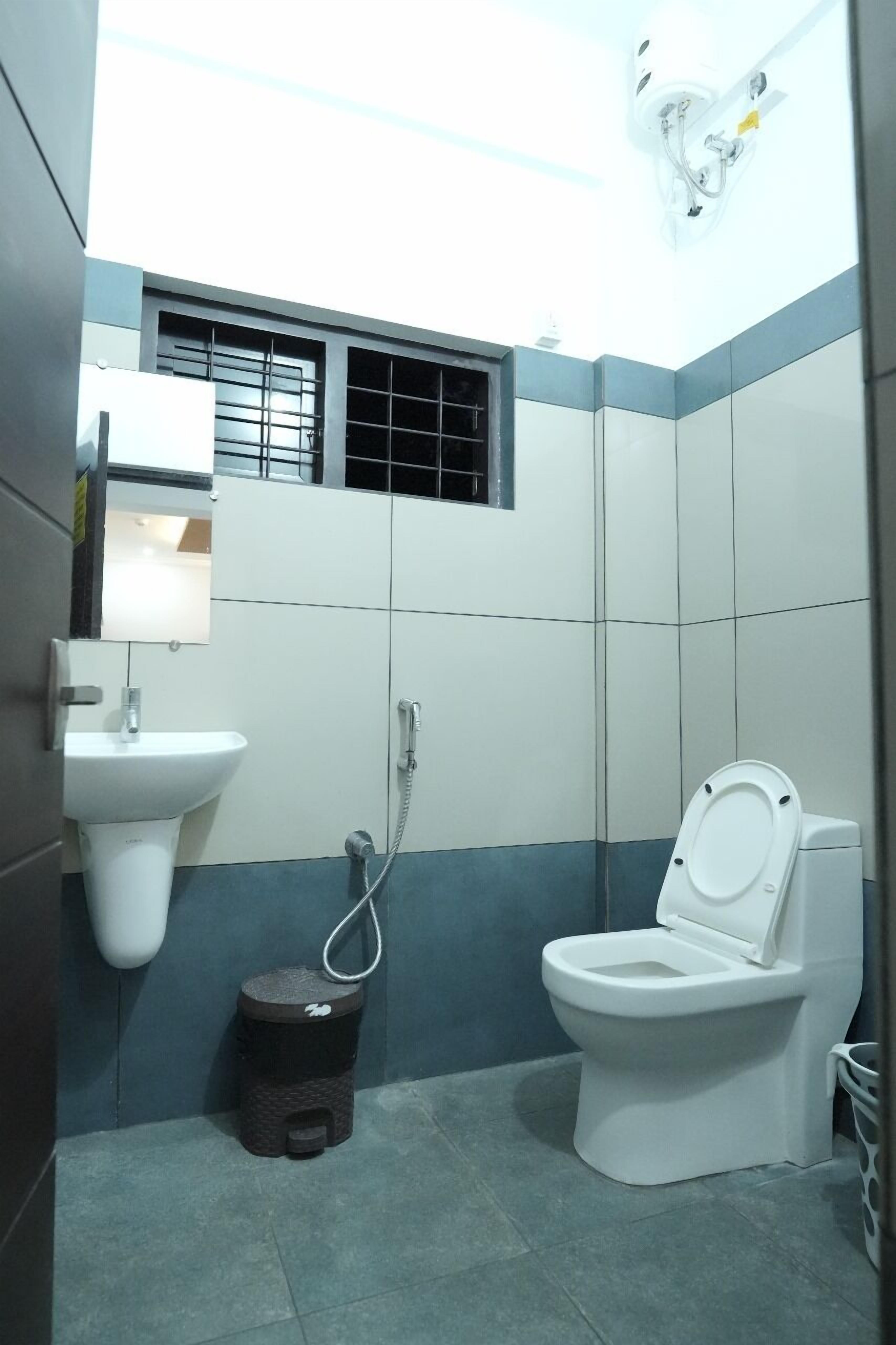 A small, compact bathroom with a toilet, sink, and shower.