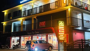 En byggnad med flera våningar, där en KFC-restaurang finns på bottenvåningen. Det finns en skylt för Alackal Arcade och en annan skylt som visar att den första våningen är tillgänglig för uthyrning eller leasing.
