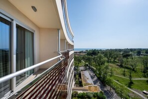 A modern building with a balcony overlooking a landscaped area.