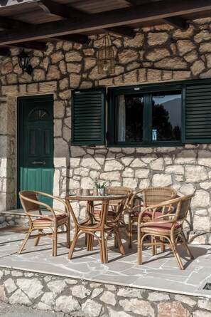 Relax in this charming outdoor seating area with wicker chairs and a small table.
