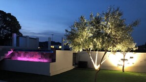 A modern outdoor area with a water feature and a tree illuminated by soft lighting. - Peace and comfort (Cessenon-sur-Orb)
