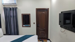 Une chambre d’hôtel équipée d’un lit, d’un téléviseur fixé au mur, d’une porte et d’un appareil de climatisation.