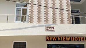 Un hôtel avec une enseigne indiquant « NEW VIEW HOTEL » et une autre enseigne, écrite en caractères arabes, au-dessus de l’entrée.