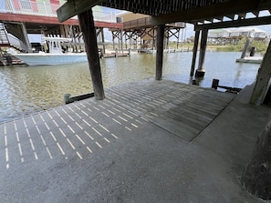 Un muelle con pasarela de hormigón y un barco amarrado al final.