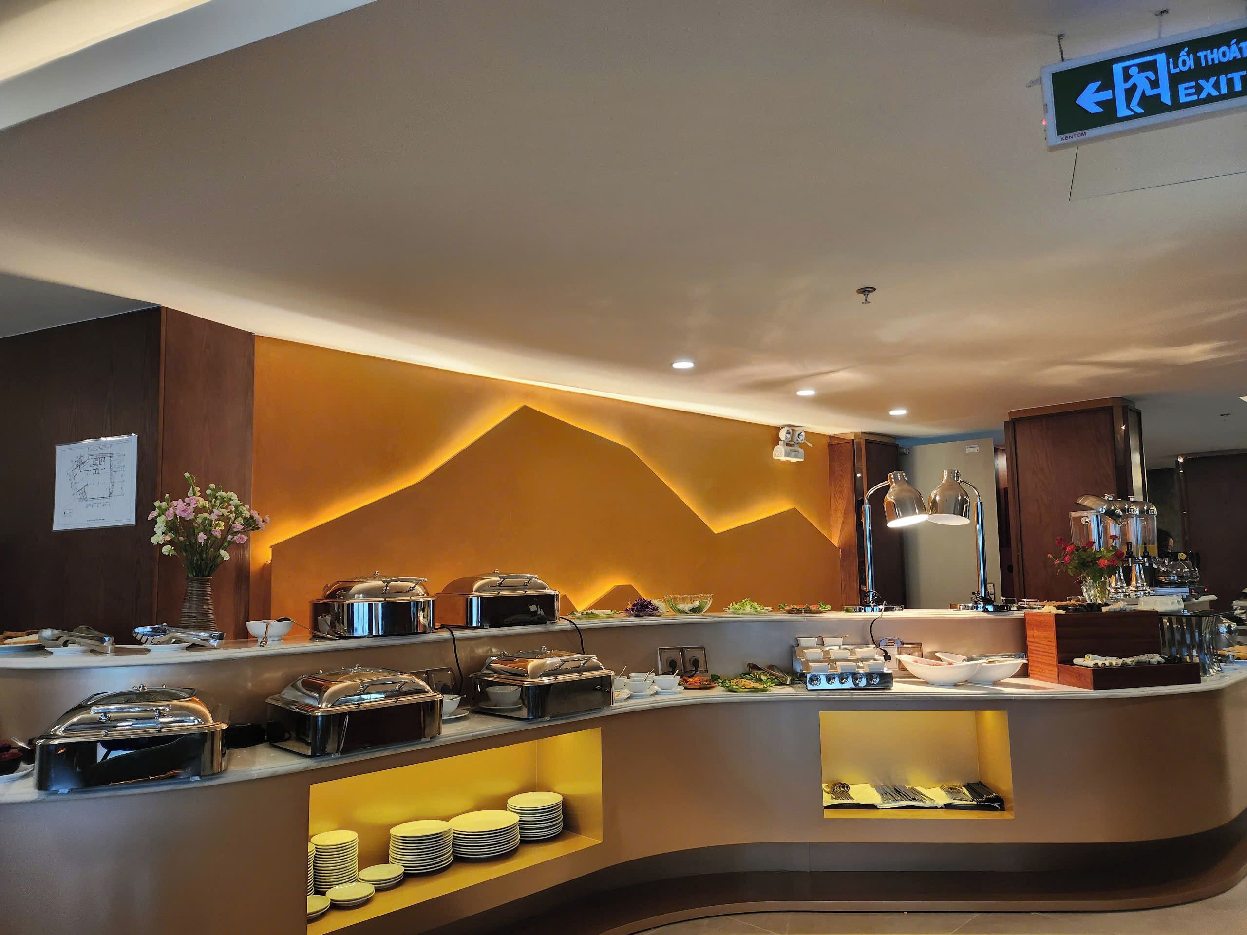 A buffet area with various food stations, a clear exit sign, and a modern interior design.