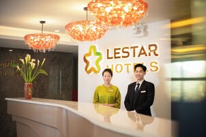 Mostrador de recepción en Lestar Hotels con un diseño moderno, un gran letrero con el nombre del hotel y elegantes candelabros.