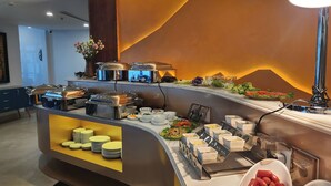 Montaje de bufé con diversos alimentos y utensilios para servir.