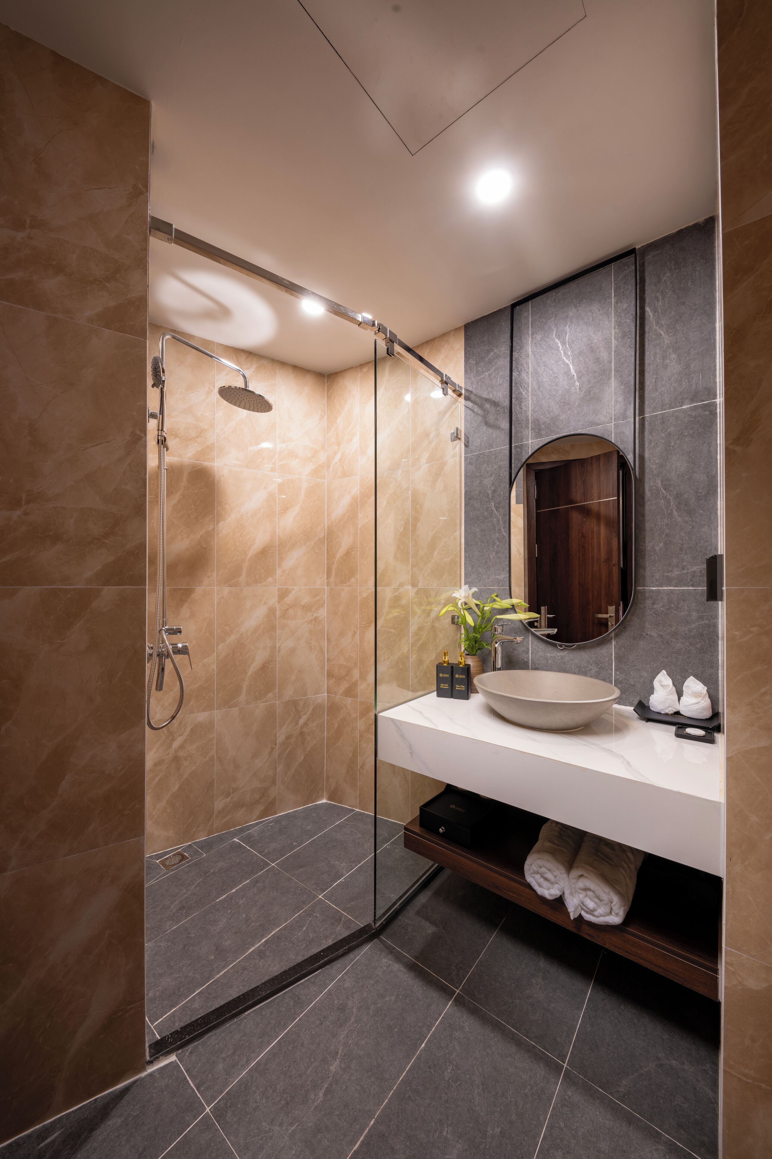 A modern bathroom with a glass-enclosed shower, a large sink, and a mirror.