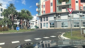 Une vue de rue avec un bâtiment abritant un centre médical, des palmiers et un panneau de signalisation.