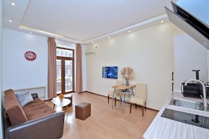 Relax in this stylish living area with a comfortable sofa, flat-screen TV, and city view.