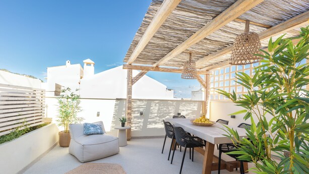 A rooftop patio with a table and chairs, a hanging light fixture, and potted plants. - Old Town Charm-Cozy 2BR with Rooftop (Rethymno)