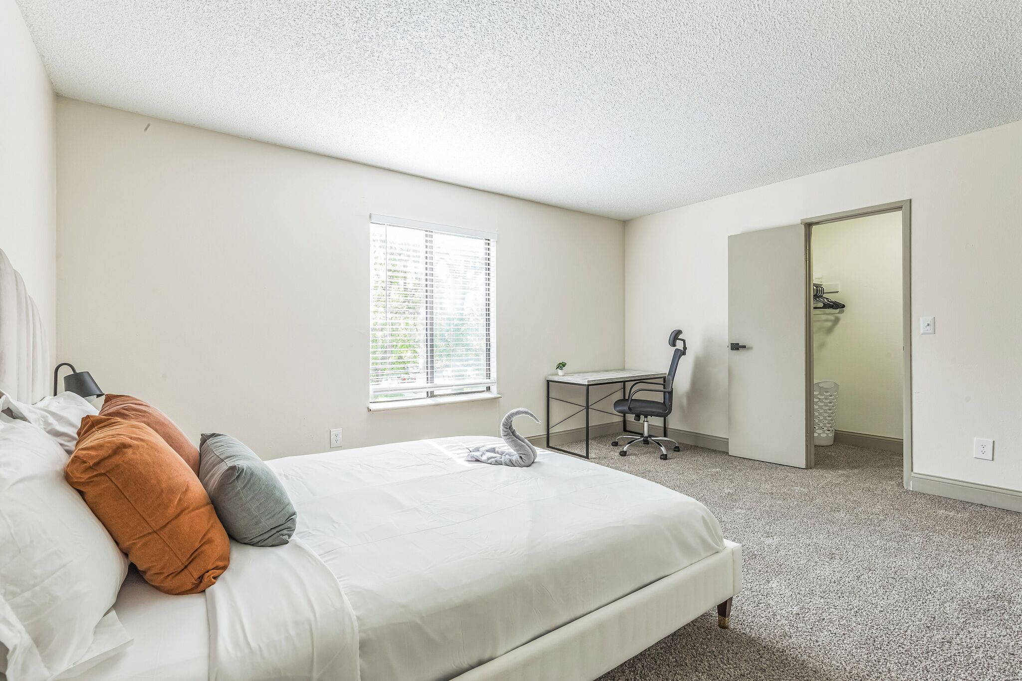 Un dormitorio con cama, escritorio y zona de ducha.