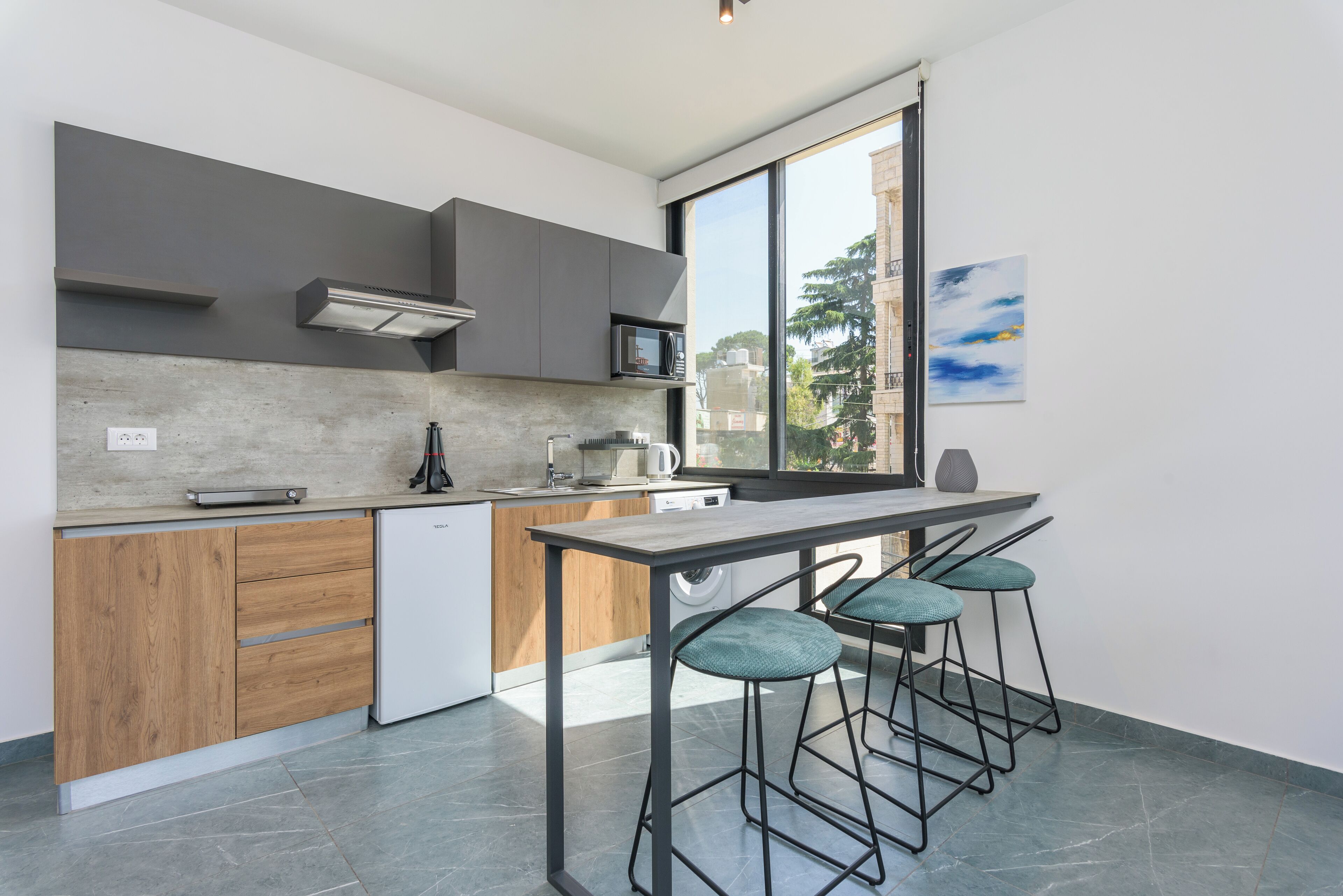 Una cocina moderna con lavavajillas integrado, microondas y un ventanal con vistas a la ciudad.