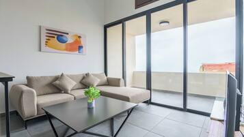 Ein modernes Wohnzimmer mit einer Couch, einem Couchtisch und einem Gemälde an der Wand.