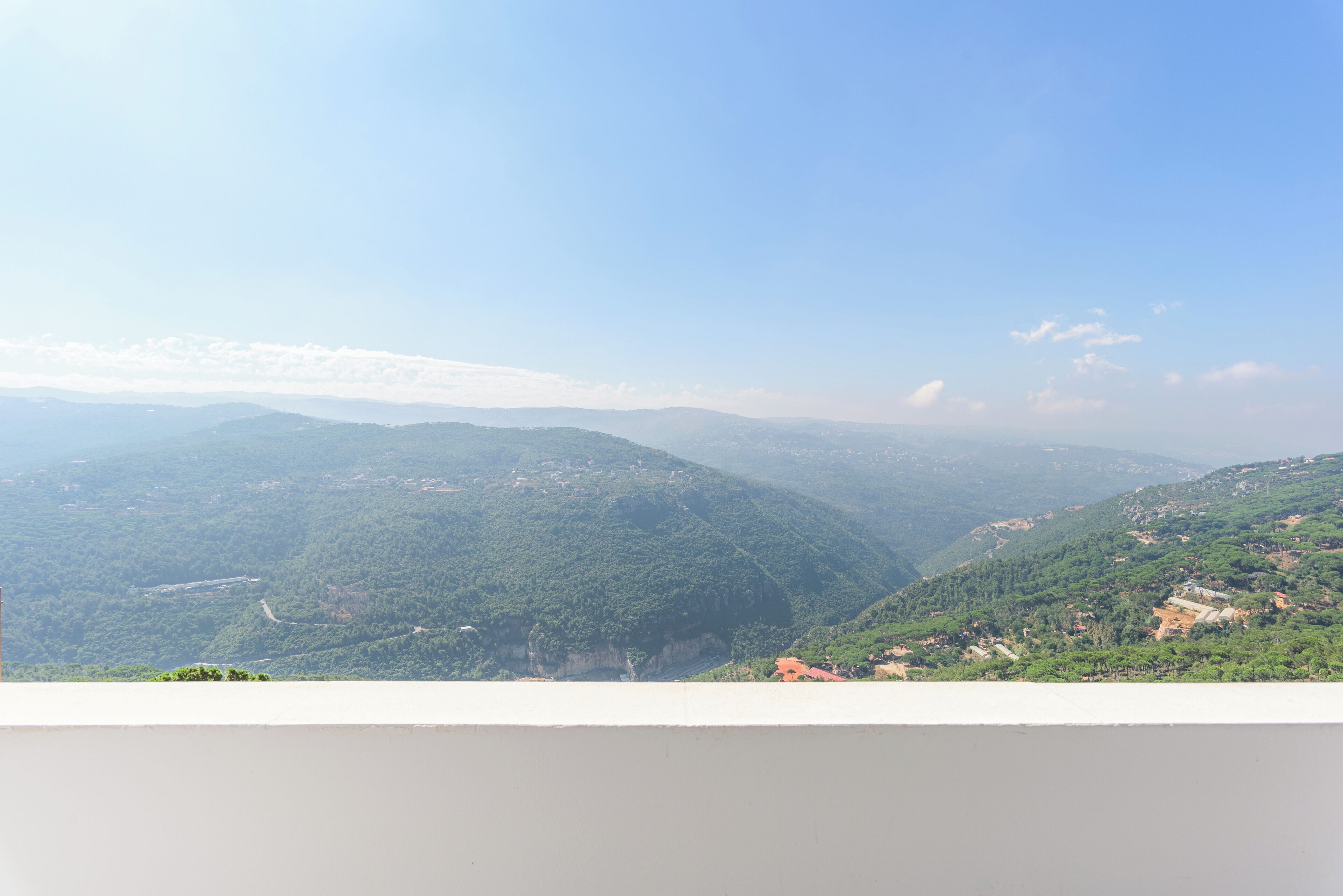 Vista panorâmica de uma paisagem montanhosa sob um céu claro.