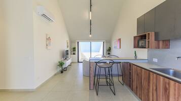 Una cocina moderna con una isla central, taburetes de bar y un horno empotrado.