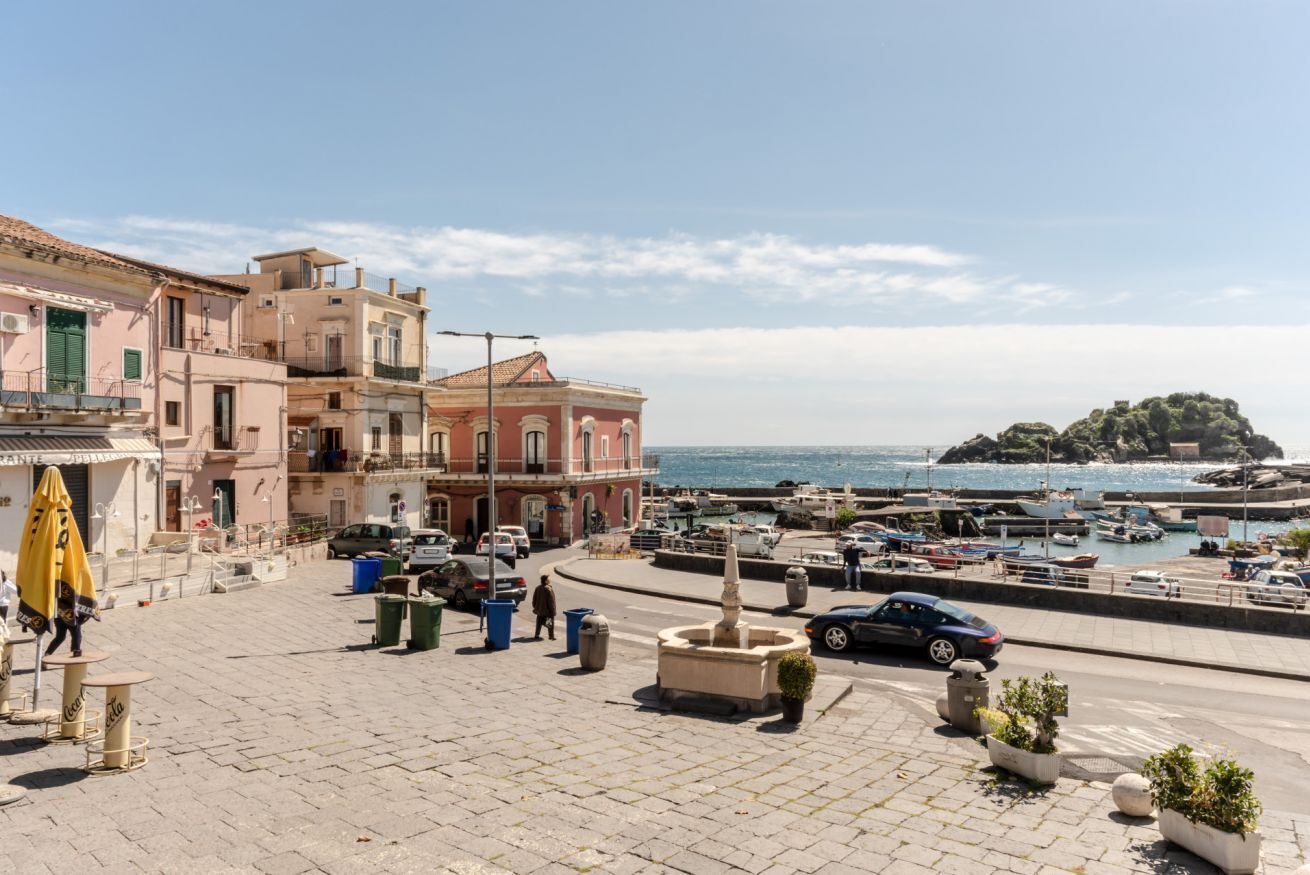 Une ville côtière avec des bâtiments, un port de plaisance et une petite île.