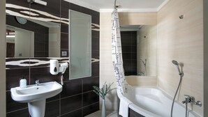 A modern bathroom with a white sink, a large mirror, a shower area, and a bathtub. - The Royal Patch Aparthotel (Kraków)