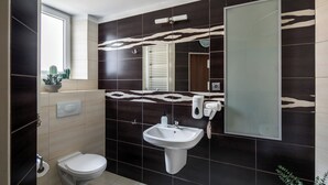A bathroom with a toilet, sink, and mirror. - The Royal Patch Aparthotel (Kraków)