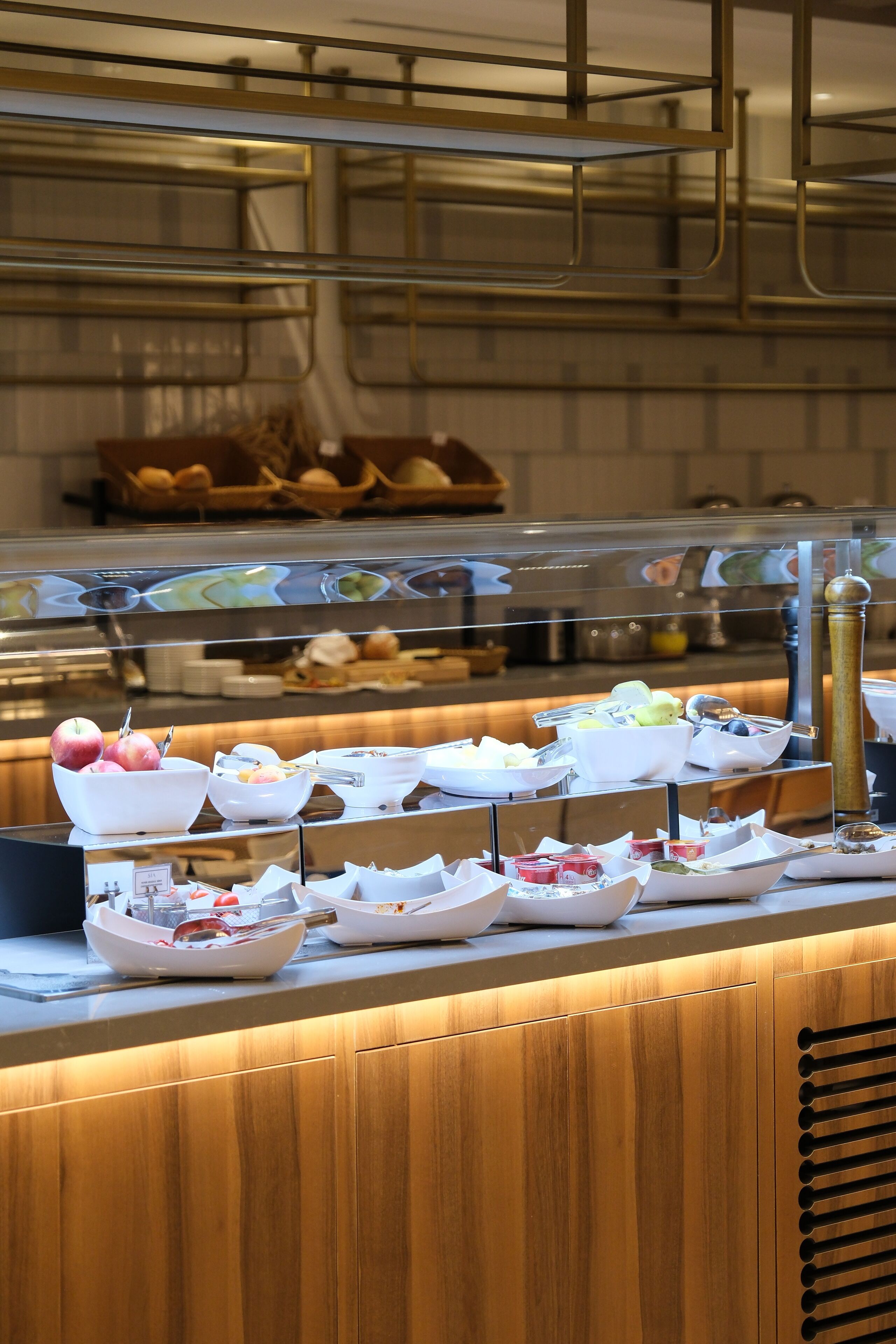 A buffet counter with various food items and utensils.