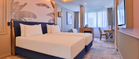 A hotel room with a large bed, a desk, and a TV.