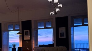 Una stanza con ampie finestre, un lampadario e vista sul cielo.