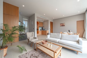 Relax in this stylish space with a comfortable sofa, chair, and dining table.