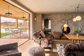 A modern living room with a fireplace, patterned furniture, and a view of the outdoors.