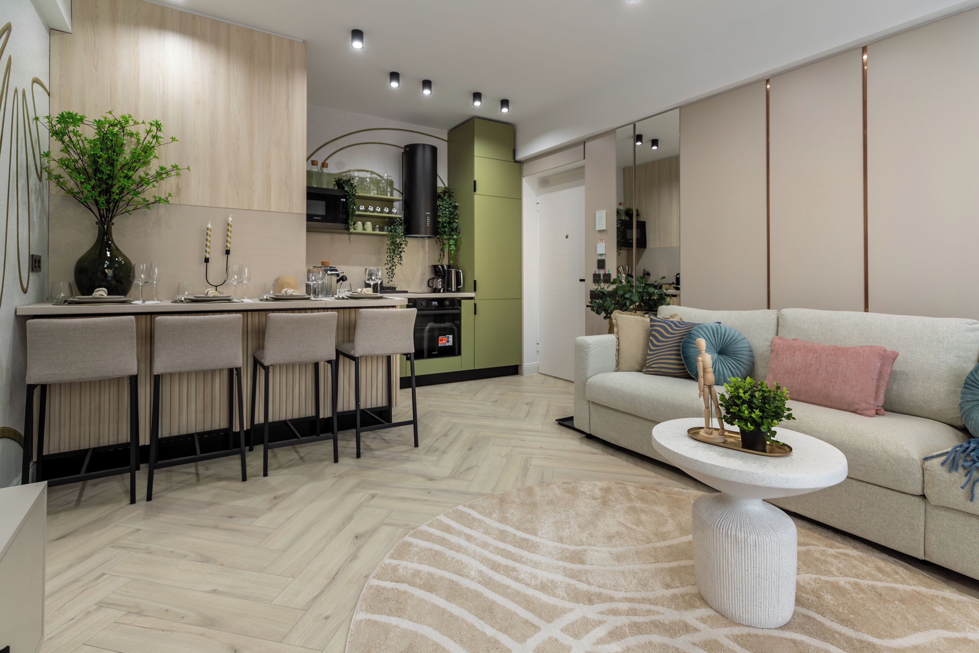 A modern kitchen with a dining area, a sofa, and a coffee table.