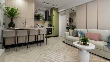 A modern kitchen with a dining area, a sofa, and a coffee table.