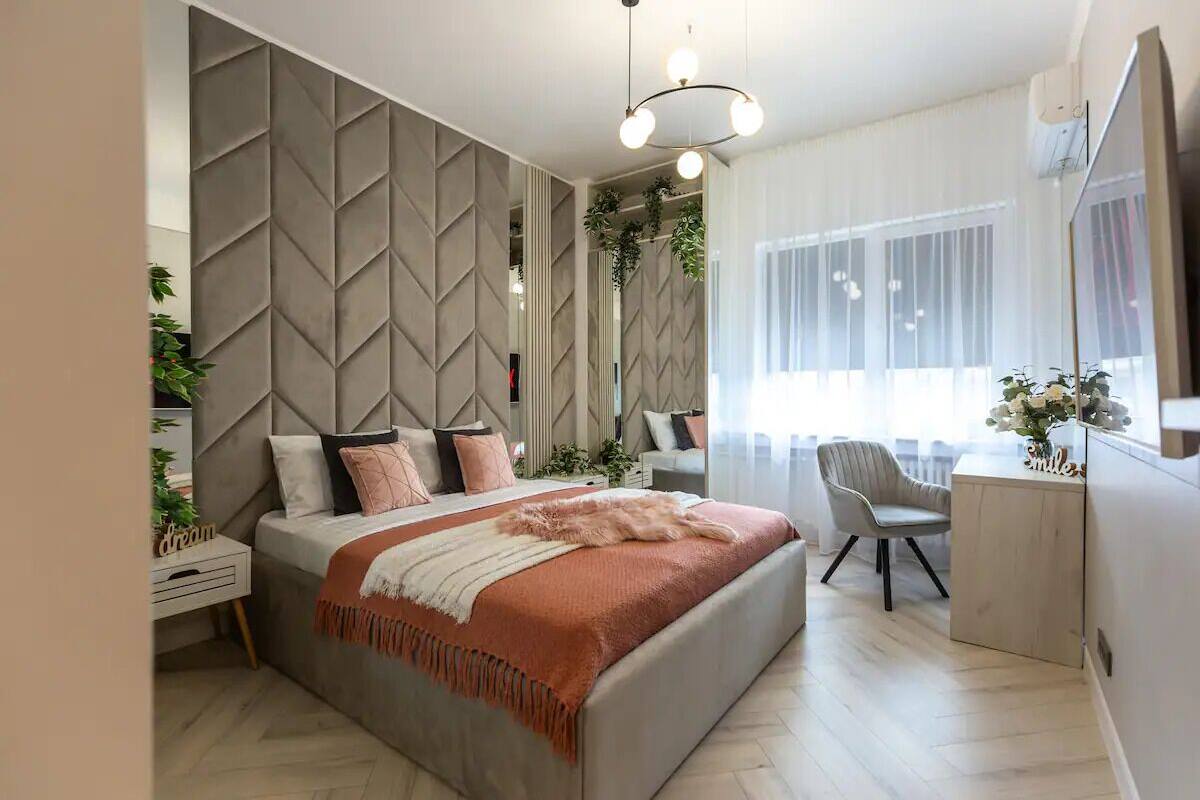 Une chambre à coucher moderne avec un lit, des tables de chevet, un bureau et une chaise.