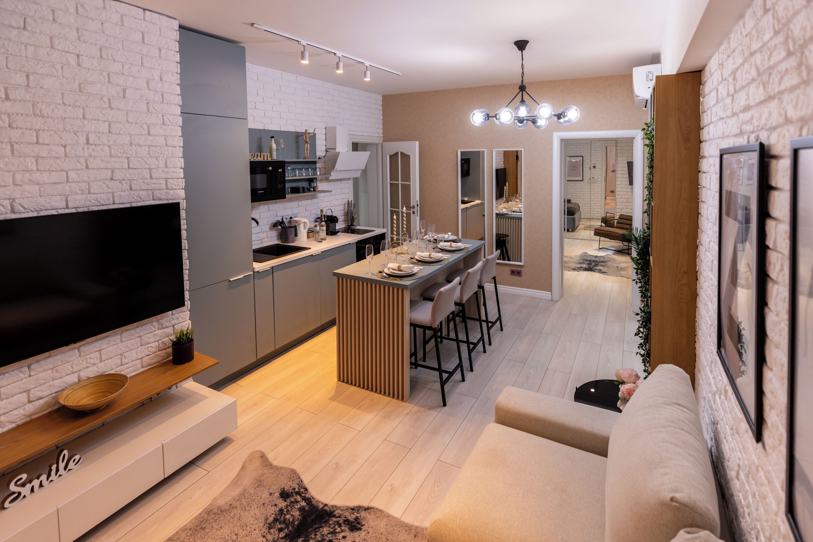 A modern kitchen with a TV, dining area, and a cozy seating space.