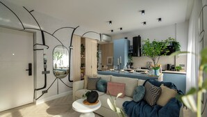 A modern living room with a sofa, coffee table, and a view into the kitchen. - Aiastay Bucharest River Apartments (Bucharest)