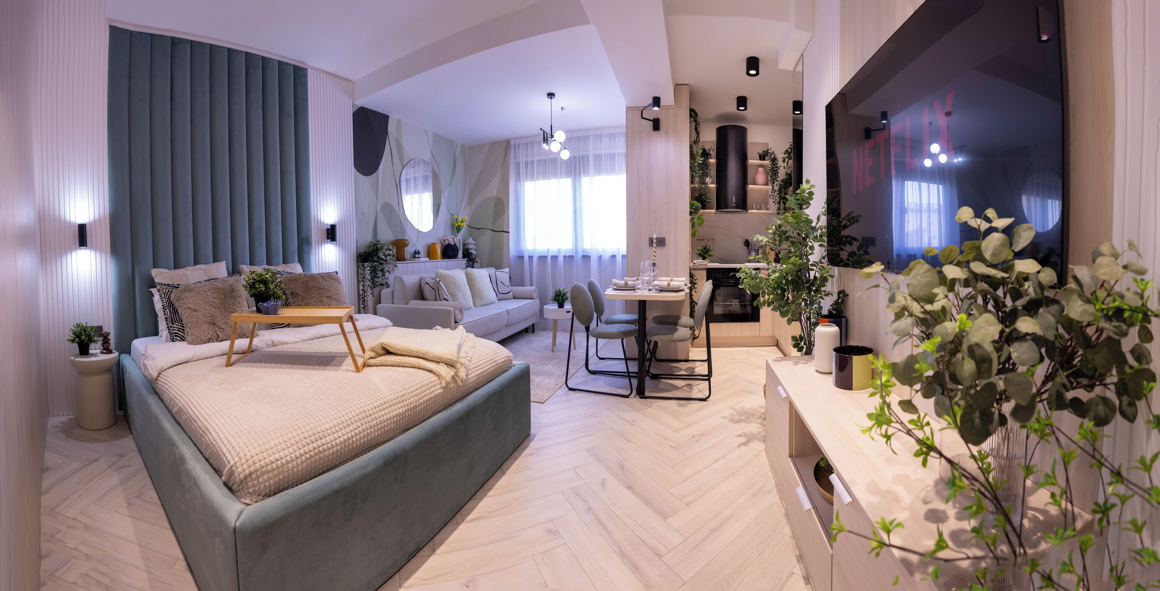 Een moderne woonkamer met een groot bed, een bank, een eethoek en een keuken.