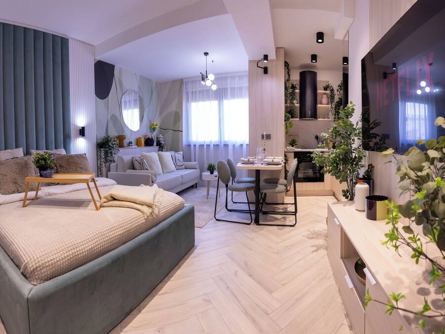 Een moderne woonkamer met een groot bed, een bank, een eethoek en een keuken.