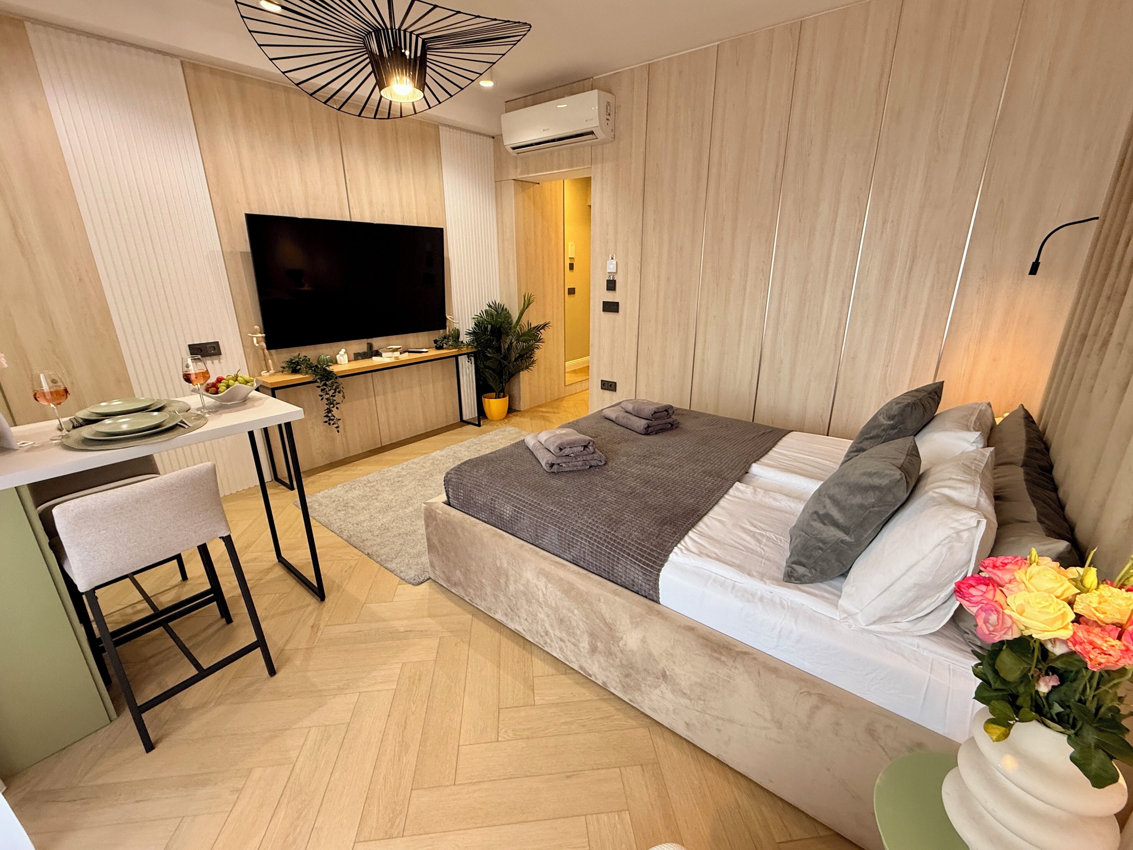 Un dormitorio moderno con una cama grande, un escritorio y un televisor.