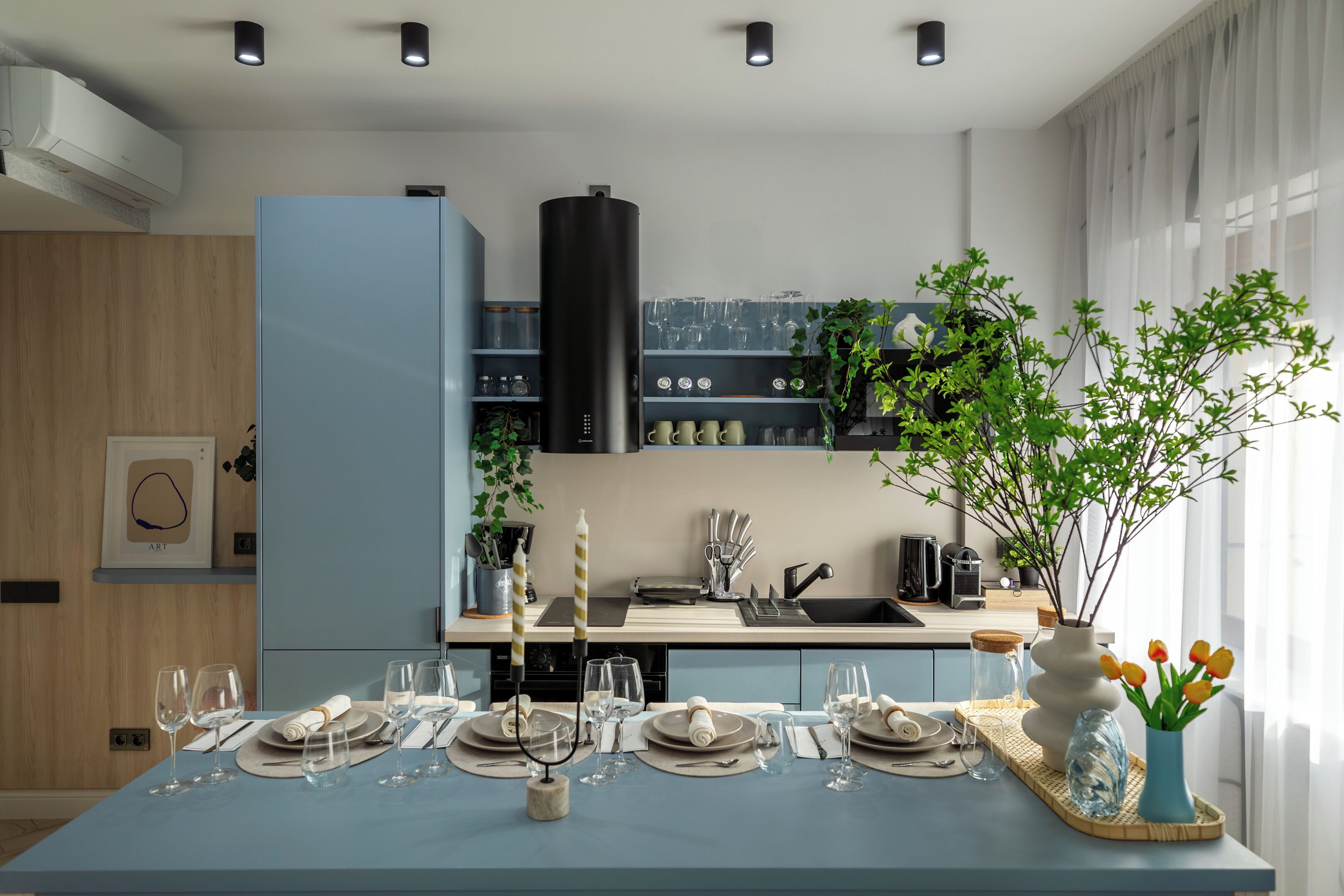 A modern kitchen with a blue countertop, a built-in stove, and a window with a view.