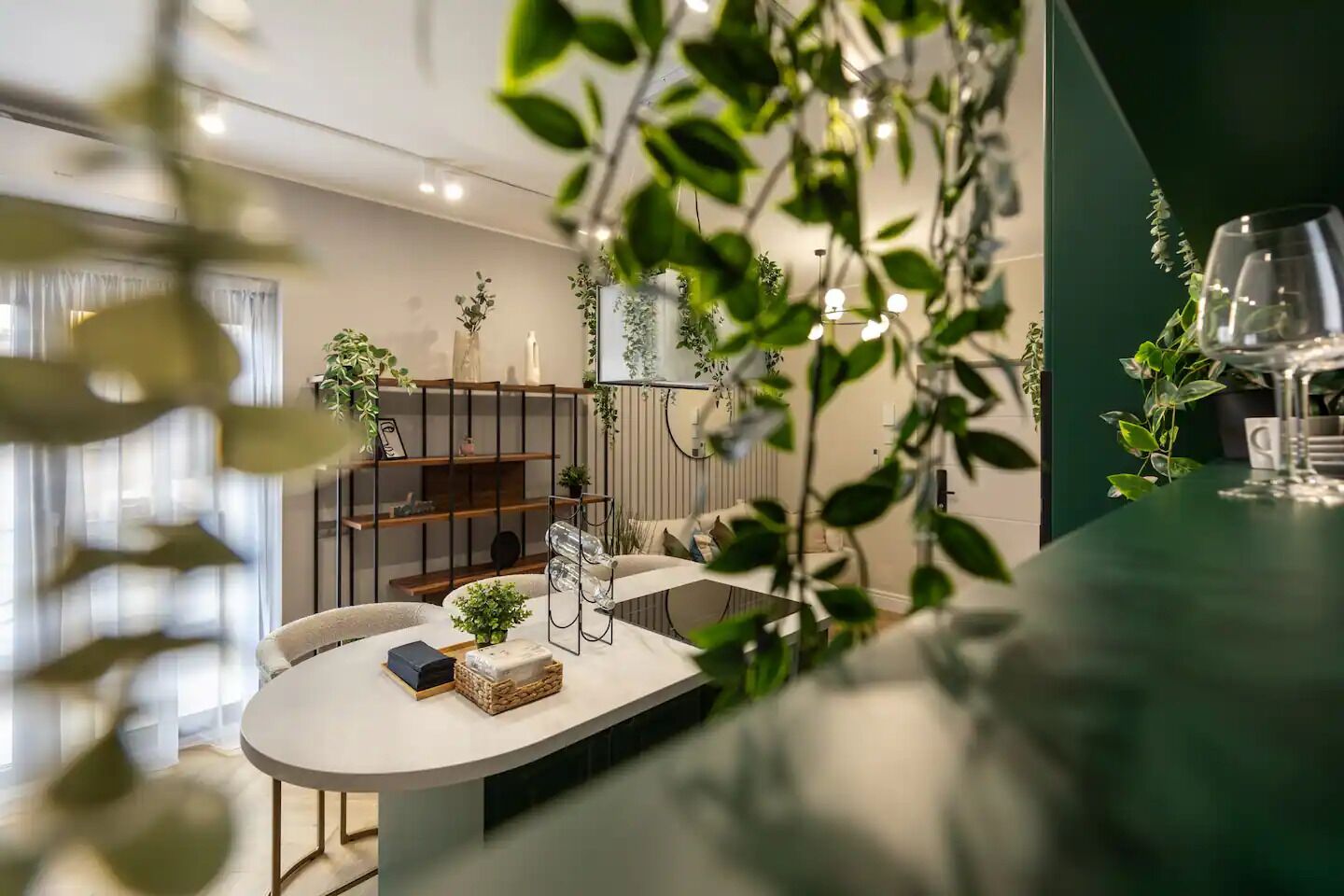 Et moderne spiseområde med et rundt bord, stole og forskellige planter.