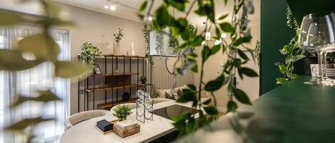 Et moderne spiseområde med et rundt bord, stole og forskellige planter.